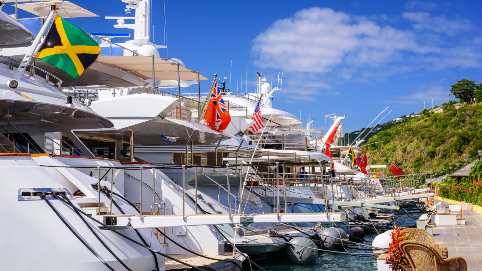 Superyacht bows with maritime flags illustrating yacht insurance policy exclusions
